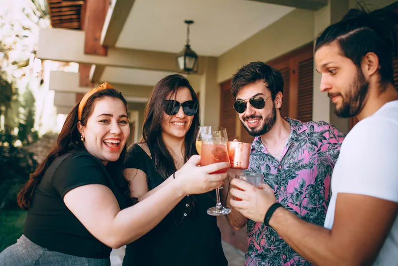 Freundesgruppe stösst mit Drinks im Freien an einer Feier an