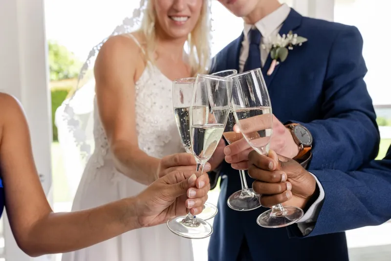 Brautpaar und Gäste stossen auf der Hochzeit an